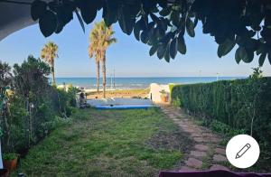 uma vista para a praia a partir do quintal de uma casa em Casa Isis Garden em Matalascañas
