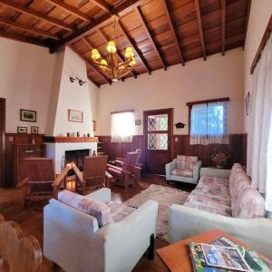 een grote woonkamer met banken en een open haard bij Casa de temporada La Villa - Long Stay - min 7 dias in Campos do Jordão