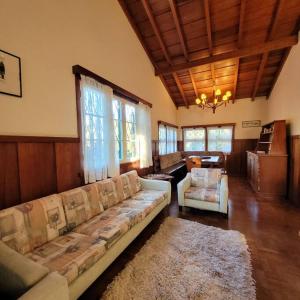 een grote woonkamer met een bank en een tafel bij Casa de temporada La Villa - Long Stay - min 7 dias in Campos do Jordão