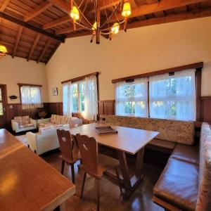 een woonkamer met een tafel en een bank bij Casa de temporada La Villa - Long Stay - min 7 dias in Campos do Jordão