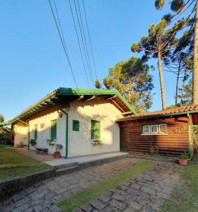 een klein huis met een groen dak erop bij Casa de temporada La Villa - Long Stay - min 7 dias in Campos do Jordão
