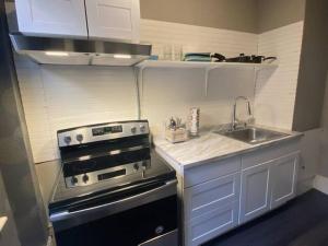 uma pequena cozinha com um fogão e um lavatório em Premier Suites Bay Village em Boston