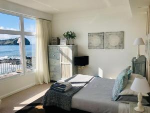 a bedroom with a bed with a view of the ocean at A Villa by the Sea Bed & Breakfast in Vila Franca do Campo