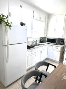 風鈴草市的住宿－Cottage Stay: near LA & OC，白色的厨房配有桌子和冰箱
