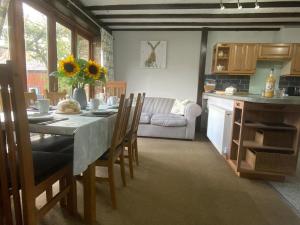 a kitchen and dining room with a table and chairs at Foxglove Barn in South Brent