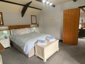 - une chambre avec un lit et 2 serviettes dans l'établissement Foxglove Barn, à South Brent
