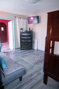 a living room with a bed and a dresser at Be steps away from the beach - Downtown Rosarito in Rosarito