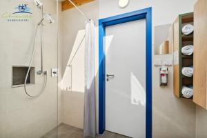 a shower with a blue door in a bathroom at Panorama Apartments by Chiemsee barrierefrei in Nußdorf +128 photos