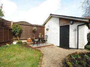 a small house with a black door and a table at Larksworthy Cottage in North Tawton