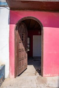 um edifício cor-de-rosa com uma grande porta de madeira em Be steps away from the beach - Downtown Rosarito em Rosarito