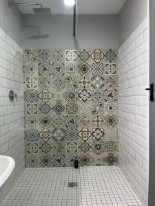 a bathroom with a shower with a tiled wall at 102 Vyfer, De Kelders in De Kelders +35 photos