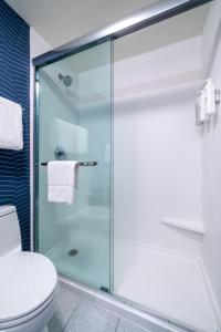 a glass shower in a bathroom with a toilet at Spark by Hilton Savannah Airport in Savannah