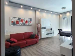 a living room with a red couch and a table at Appartamento Maggi in Brescia