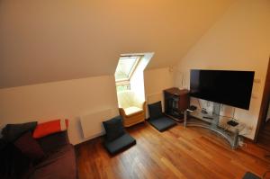 ein Wohnzimmer mit Flachbildfernseher und Stühlen in der Unterkunft Maison à la campagne proche Disney in Couilly-Pont-aux-Dames