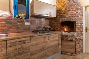 a kitchen with a brick wall and a fireplace at Otus in Kraj