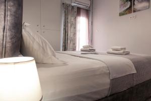 een witte slaapkamer met 2 bedden en handdoeken bij Suite 04 - Smart Cozy Suites - In the heart of Athens - 5 minutes from Metro in Athene