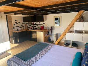 um quarto grande com uma cama e uma cozinha em Petit chalet em Nernier