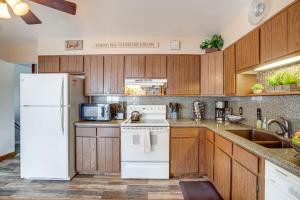 a kitchen with wooden cabinets and a white refrigerator at Near Red Rocks, Hiking and Skiing Kittredge Condo! in Kittredge
