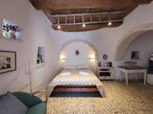 a bedroom with a bed and a couch in a room at Trulli La Cariola in Locorotondo