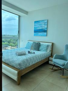 a bedroom with a bed and a chair and a window at Condo Gorgona Beach Apartamento de Lujo de 2 Habitaciones in Chame