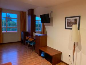 a room with a desk and a table in a room at Hotel Barreiro in Leira