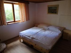 een slaapkamer met een bed in een kamer met een raam bij Chata U Selské rokle in Doksy
