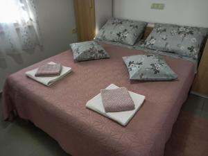 ein rosa Bett mit Kissen und Servietten darauf in der Unterkunft Soba Ulika in Motovun