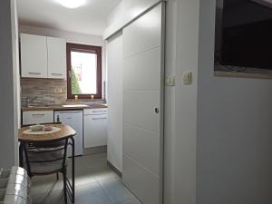 a kitchen with a small table and a kitchen with white cabinets at Soba Ulika in Motovun