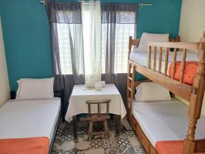 Habitación pequeña con 2 literas y mesa. en El Rancho De Don Moncho Hostel 