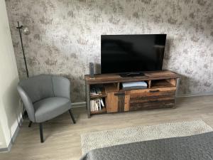 a living room with a television and a chair at Ferienwohnung LauterWein in Bernkastel-Kues