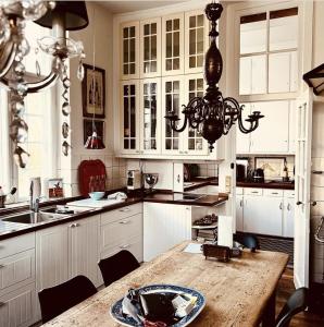 eine Küche mit einem Holztisch und einem Kronleuchter in der Unterkunft Jungshovedgaard Bed & Breakfast in Præstø