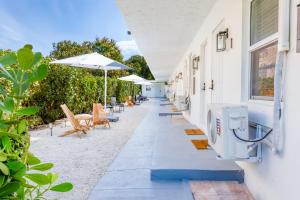 einen Gehweg mit Stühlen und Sonnenschirmen auf einem Gebäude in der Unterkunft Casa Agave Miami in Miami