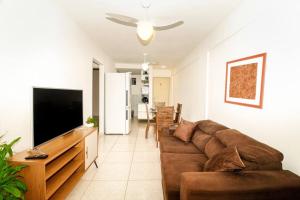 Il comprend un salon doté d'un canapé et d'une télévision à écran plat. dans l'établissement Apartamento La Casetta Ponta Negra com a Prosper, à Natal