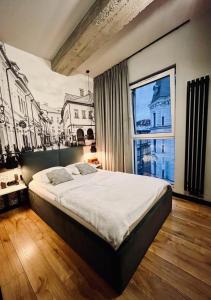 a bedroom with a large bed and a large window at Bielsko Citylife Luxury Apartment in Bielsko-Biała