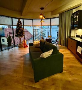 - un salon avec un canapé vert et un arbre de Noël dans l'établissement Bielsko Citylife Luxury Apartment, à Bielsko-Biała
