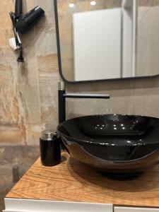 La salle de bains est pourvue d'un lavabo noir sur le comptoir. dans l'établissement Regal Apartment 2, à Tirana