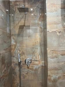 La salle de bains est pourvue d'une douche avec une porte en verre. dans l'établissement Regal Apartment 2, à Tirana