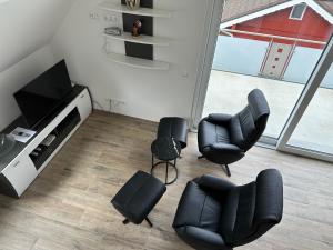 a living room with chairs and a flat screen tv at Ferienwohnung Ulrich Gebauer in Bad Staffelstein