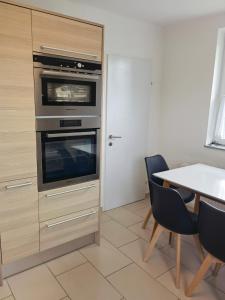 eine Küche mit einem Backofen und einem Tisch mit Stühlen in der Unterkunft Haus in Murfeld Graz in Graz