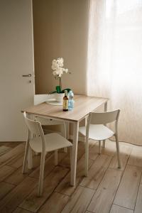 una mesa de comedor y sillas con un jarrón de flores en Vista Apartments Verona, en Verona