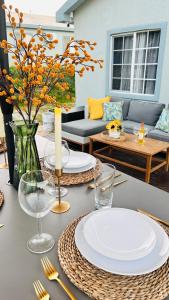 a table with plates and glasses on top of it at Mid-Century Modern Charm in Discovery Bay