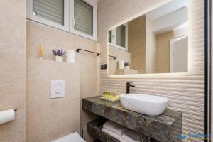a bathroom with a sink and a mirror at Seafront Residence Makarska in Makarska +104 photos
