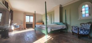 um quarto com uma cama de dossel e uma cadeira em CASA-Villa Grinnell em Grasse