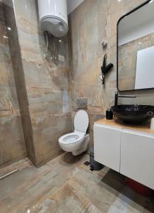 La salle de bains est pourvue de toilettes et d'un lavabo. dans l'établissement Regal Apartment 2, à Tirana
