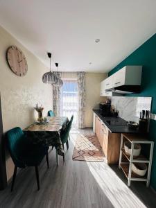 a kitchen with a table and a clock on the wall at Apartament U Bartusia in Zakopane