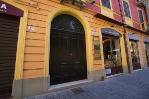 a building with a large black door on a street at Mazzini's Rooms in Modena