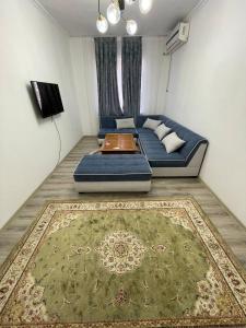 a living room with a blue couch and a rug at 3 xona kvartira in Tashkent