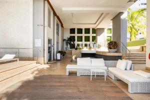 a living room with two white couches and a table at U-GO Edificio Murano Elite Bocagrande Frente al Mar in Cartagena de Indias