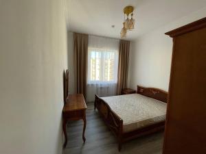 1 dormitorio con cama, mesa y ventana en 3 xona kvartira, en Tashkent