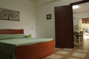 a bedroom with a bed and a door to a dining room at B&B La Petite Maison in Santa Domenica